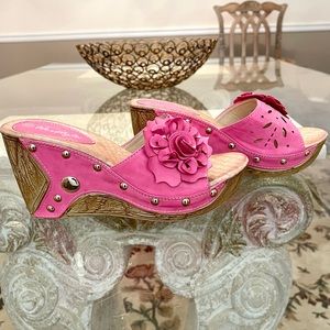 Pink laser cut slip on sandals with floral accent and silver tone studs. Size 8